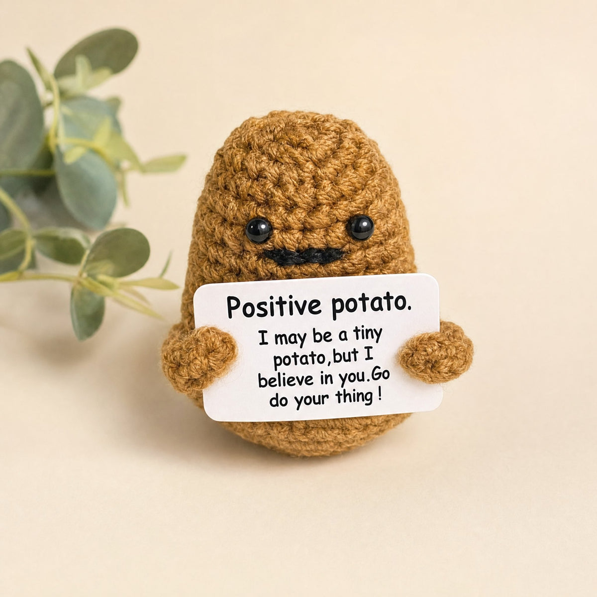 Positive Potato crochet desk buddy holding a pep-talk card